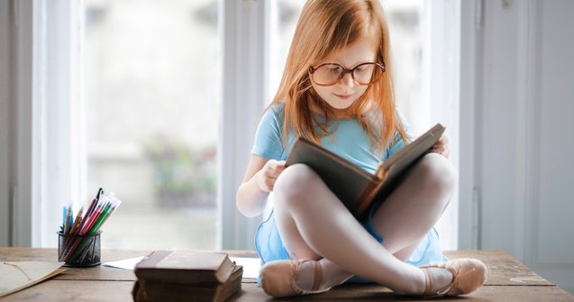 Punatukkainen tyttö lukee kirjaa