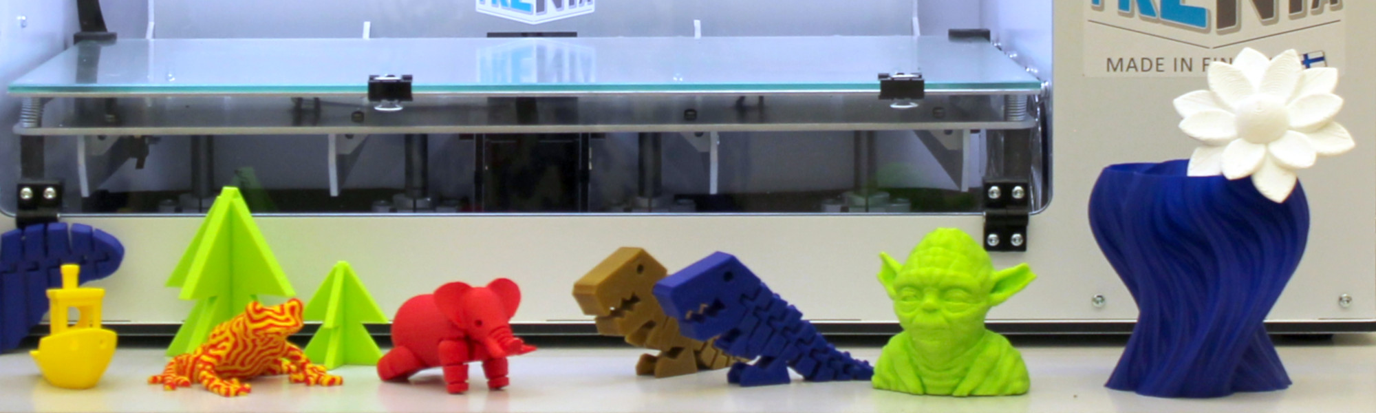 3D-tulostimella tulostettuja satuhahmoja 3D-tulostimen edessä